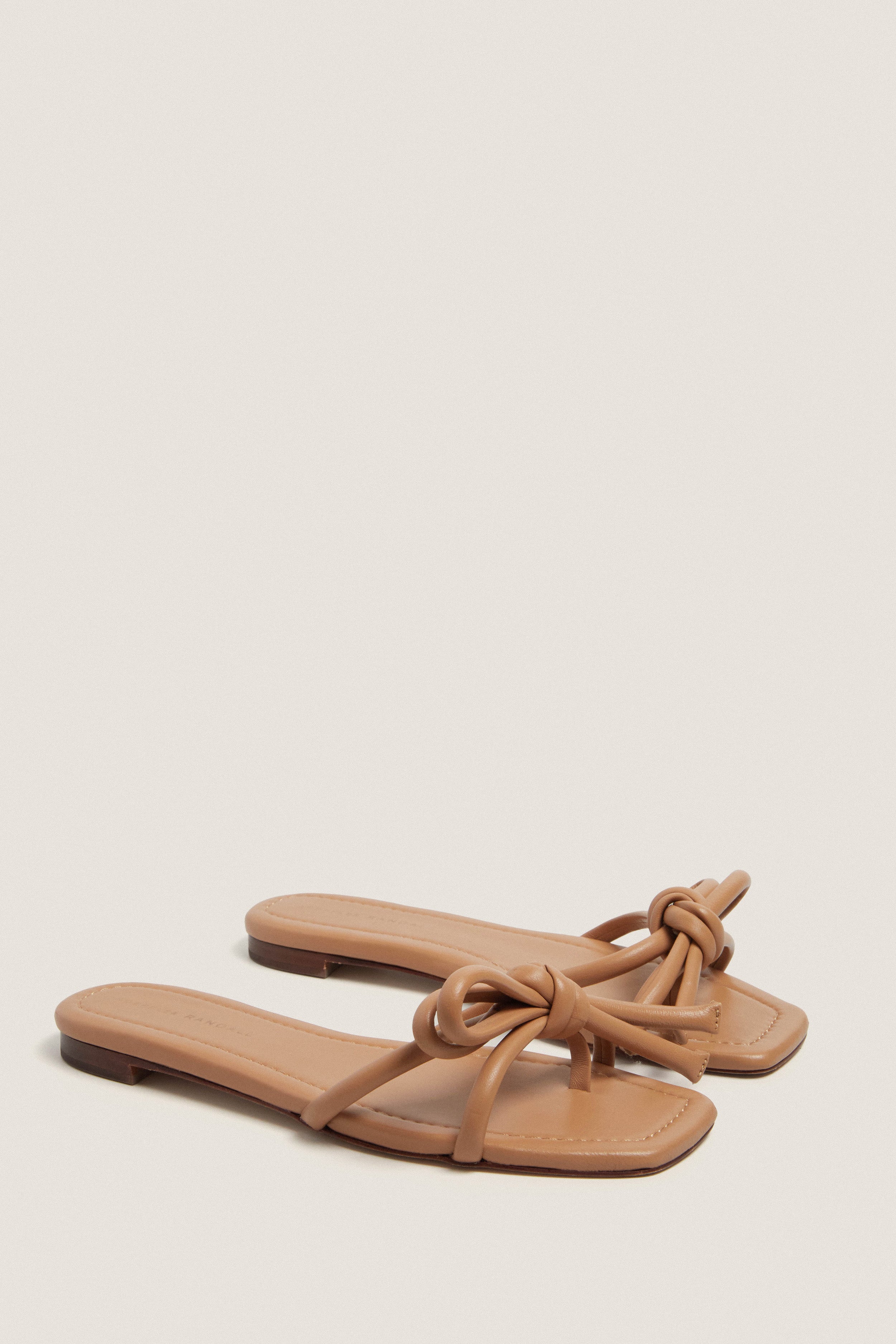 Dune Nappa Hadley Leather Bow Flat Sandal: classic and effortless slide-on flats with knotted bow detail, open square toe, and padded footbed for a fun, high-end look.