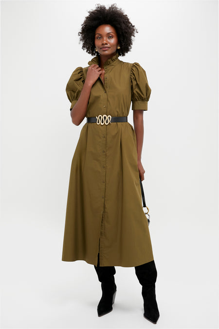 Model in olive-green shirt dress and classic Black Suede Maine Up Boots, showcasing effortless style with pointed toes and angled heels, complemented by a high-end black handbag.