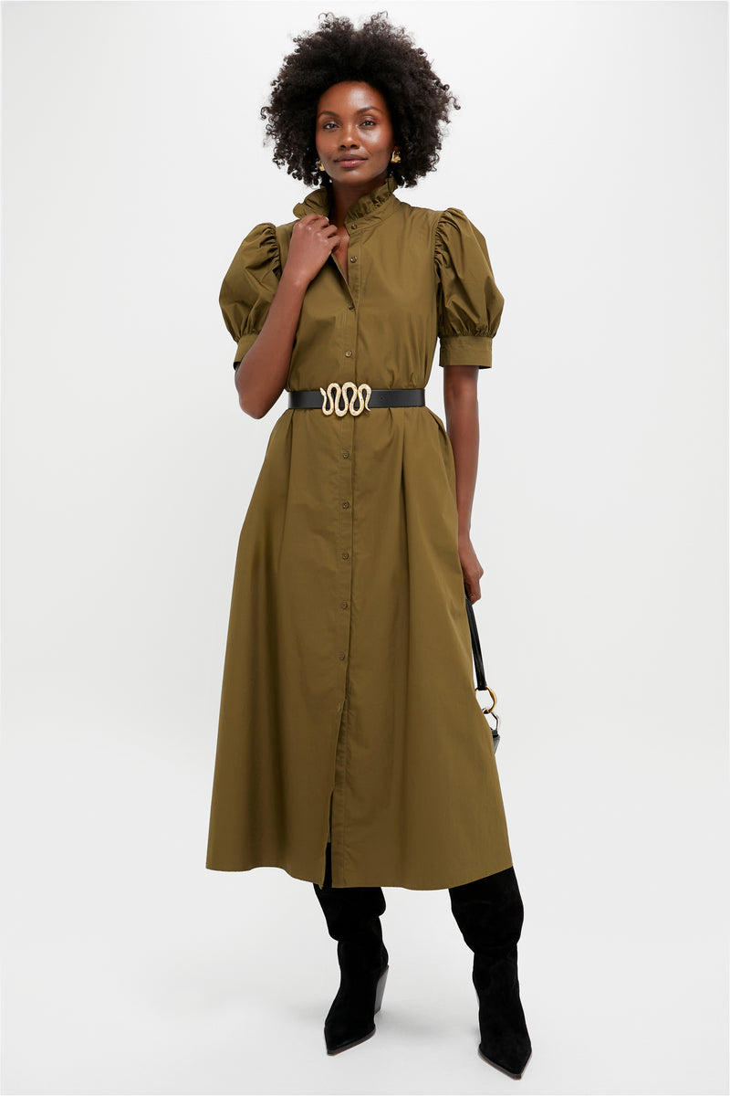 Model in olive-green shirt dress and classic Black Suede Maine Up Boots, showcasing effortless style with pointed toes and angled heels, complemented by a high-end black handbag.