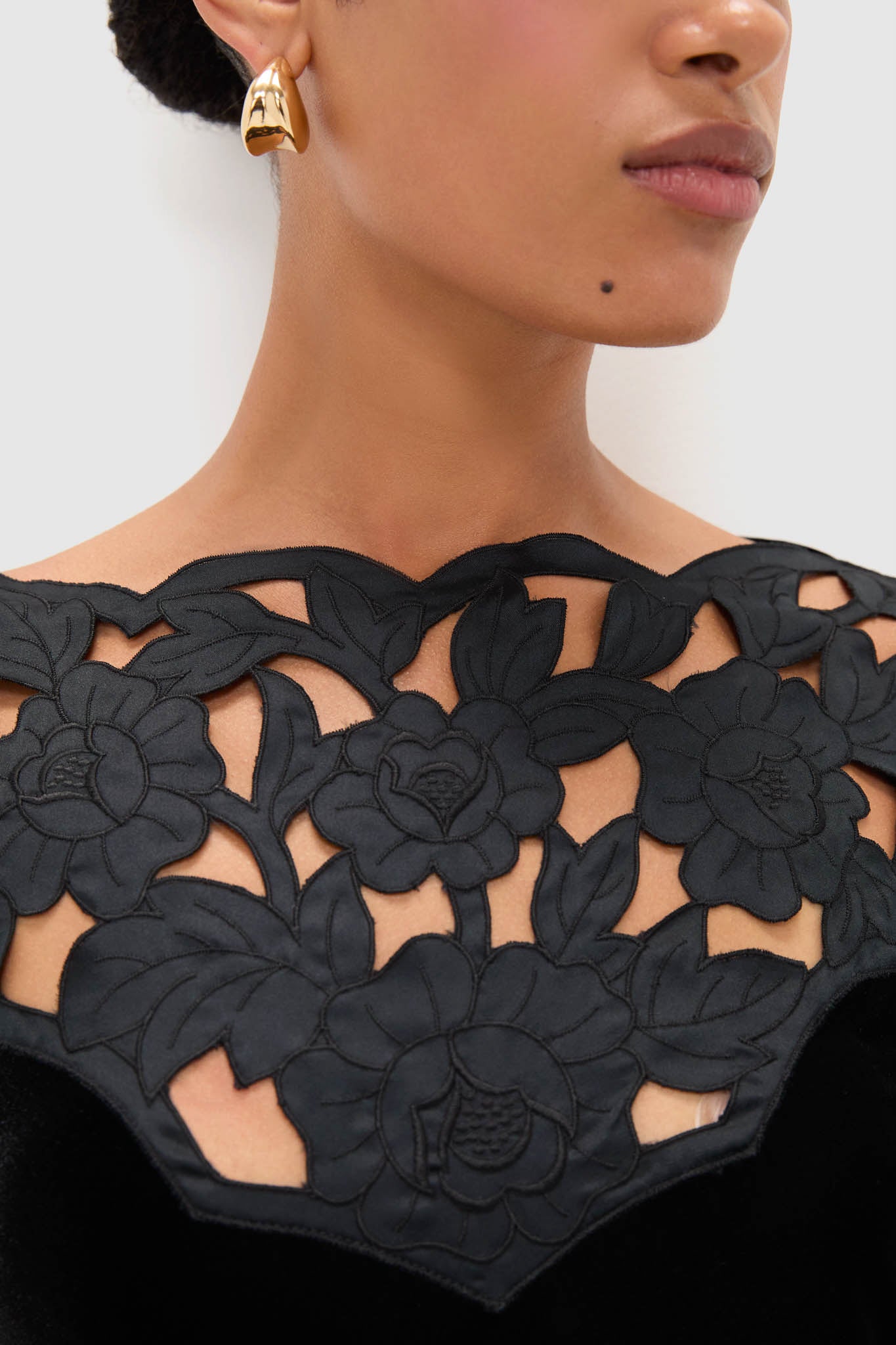 Accademia Black Velvet Bell Sleeve Catherine Maxi Dress with intricate floral lace yoke, worn with a sculptural gold earring, embodies classic and effortless high-end style.