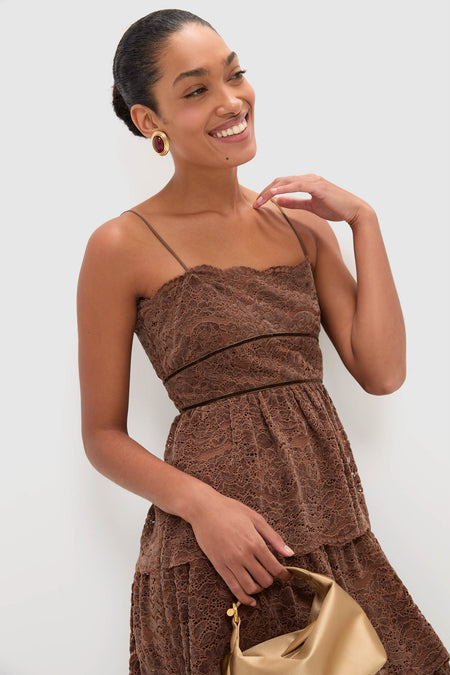 Smiling woman models the Sepia Lace Leina Midi Dress, showcasing its classic, effortless tiered skirt and fitted bodice. Paired with high-end gold accessories for a fun, elegant look.