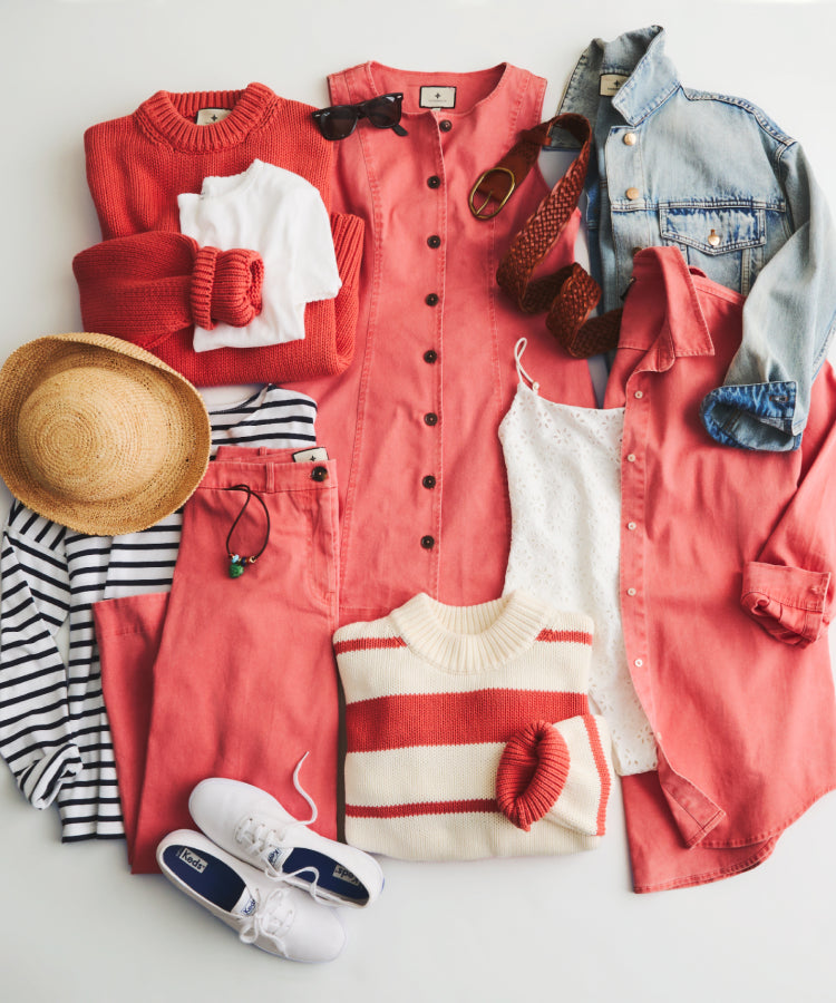 Flat lay image of Nantucket Reds™ pieces from Tuckernuck's Summer Heritage Collection layered with a straw hat, a white tee, sunglasses, a leather belt, and a jean jacket. 