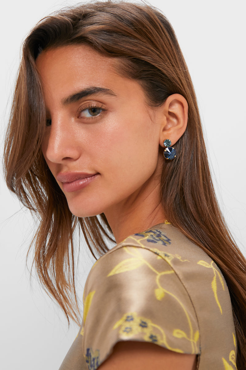 Young woman wears classic Lagoon Myrla Earrings, featuring effortless double-crystal studs in blue hues, perfect for adding fun, high-end sparkle to any outfit.