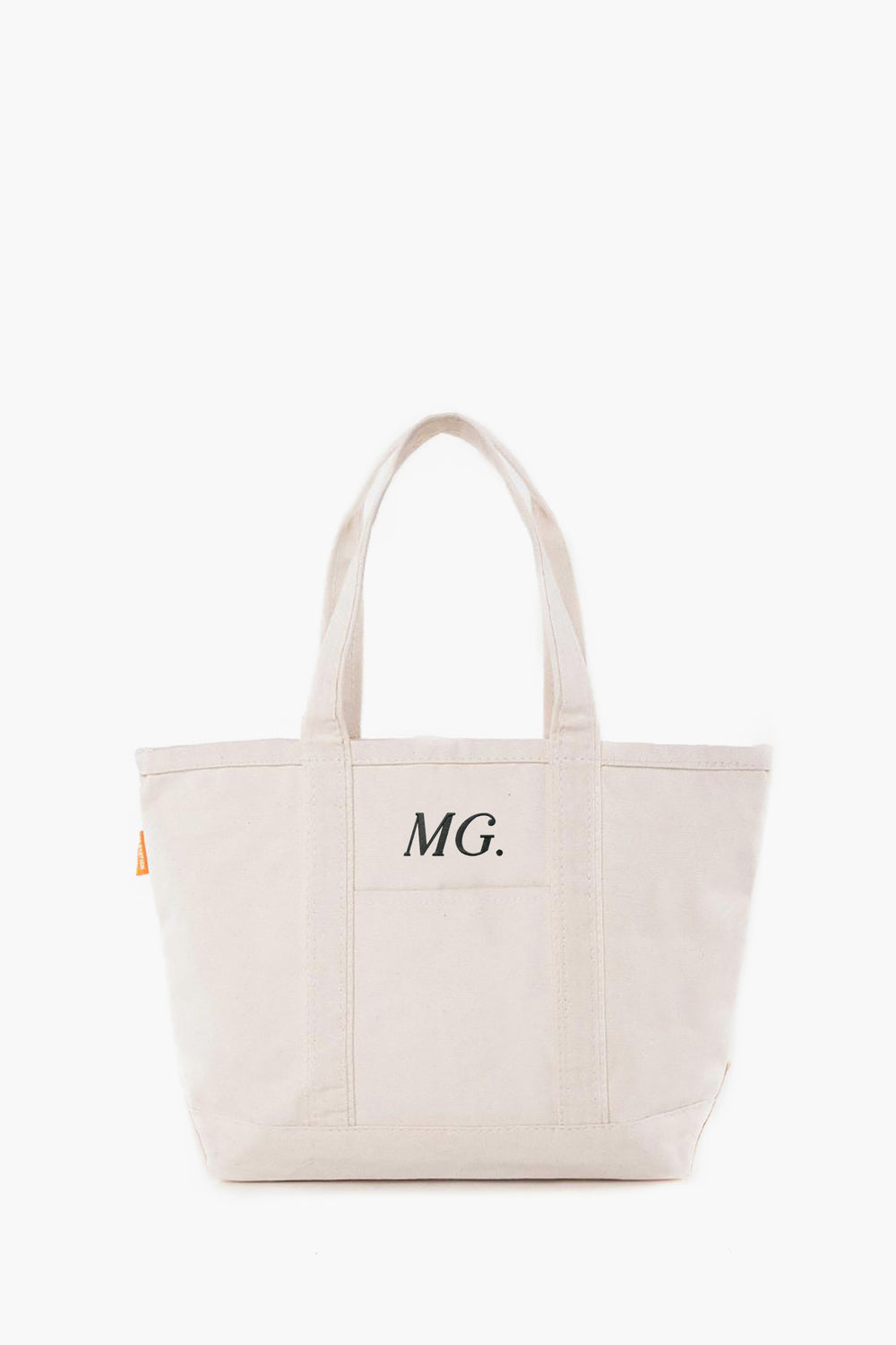 This cream-colored canvas tote by CB Station features two handles and the initials MG. printed on the front pocket.