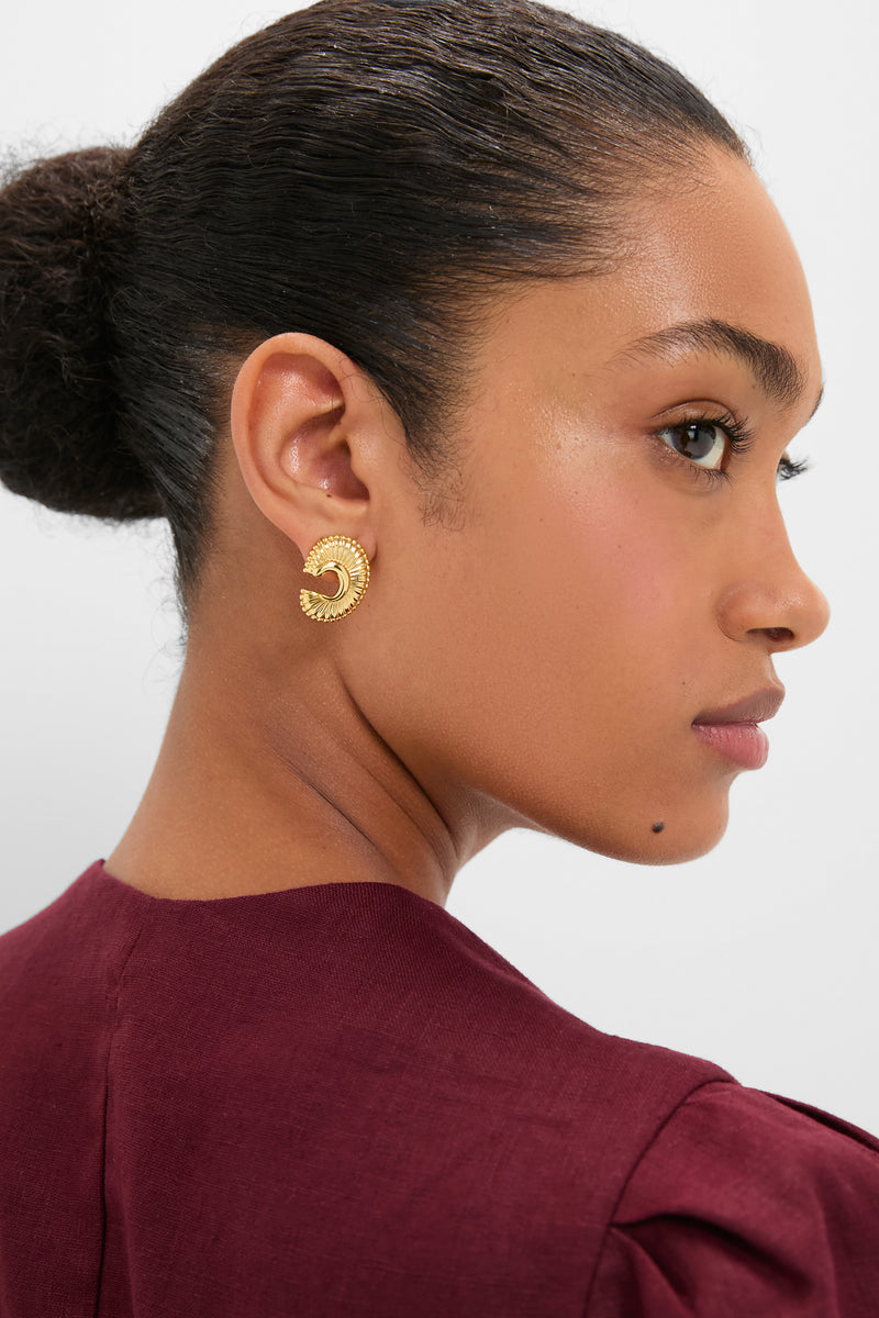 Woman wearing classic Gold Michelle Earrings, a textured, crescent-shaped stud exuding effortless elegance. Perfect for high-end occasions, aligning with Tuckernuck's fun and confident style.