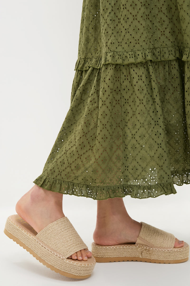 Model wearing Natural Del Mar Sandals, effortlessly blending fun and high-end style with a braided jute platform and wide strap, paired with a classic olive broderie-anglaise skirt.