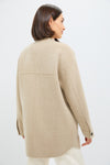 Back view of a woman in a classic, oversized Beige Chine Florian Coat with seam detailing, button cuffs, styled effortlessly with light trousers for a high-end, fun look.