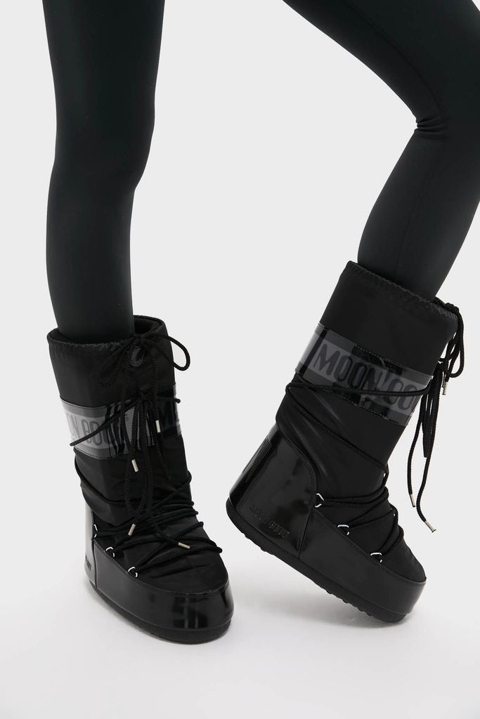 Black Icon Glance Boots, effortlessly classic and fun, feature a high-end, glossy design with lace-up details and a padded upper, ideal for adventurous style.