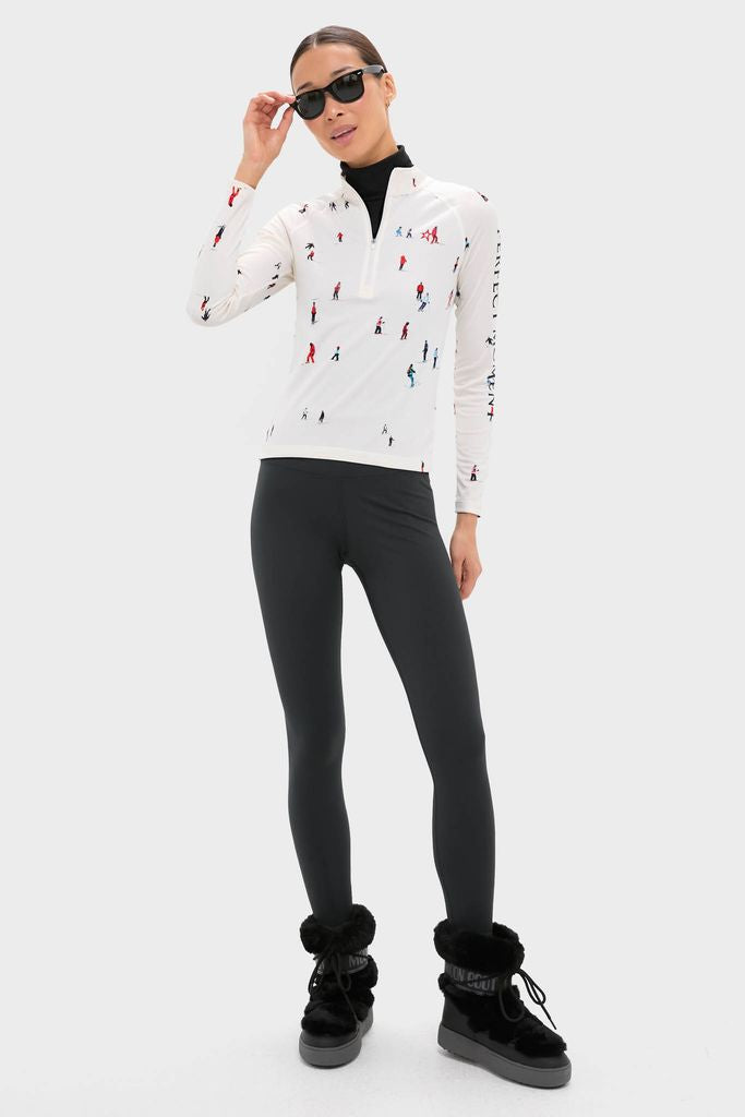 Model showcasing classic Black LTrack Faux Fur Boots, effortlessly styled with form-fitting leggings and a fun, skier-print top. Perfect for high-end winter adventures.