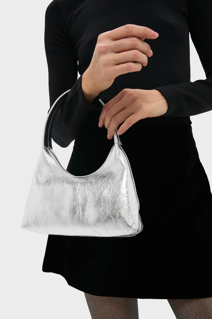 A person holds the classic Silver Mini Candy Bag, featuring an effortless crescent shape and high-end metallic finish, perfect for fun, stylish outings.