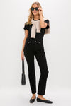 Woman in Solid Black Blaine Jean, high-rise and vintage-inspired, with effortless style; paired with black top and accessories, exuding classic, fun, high-end elegance.