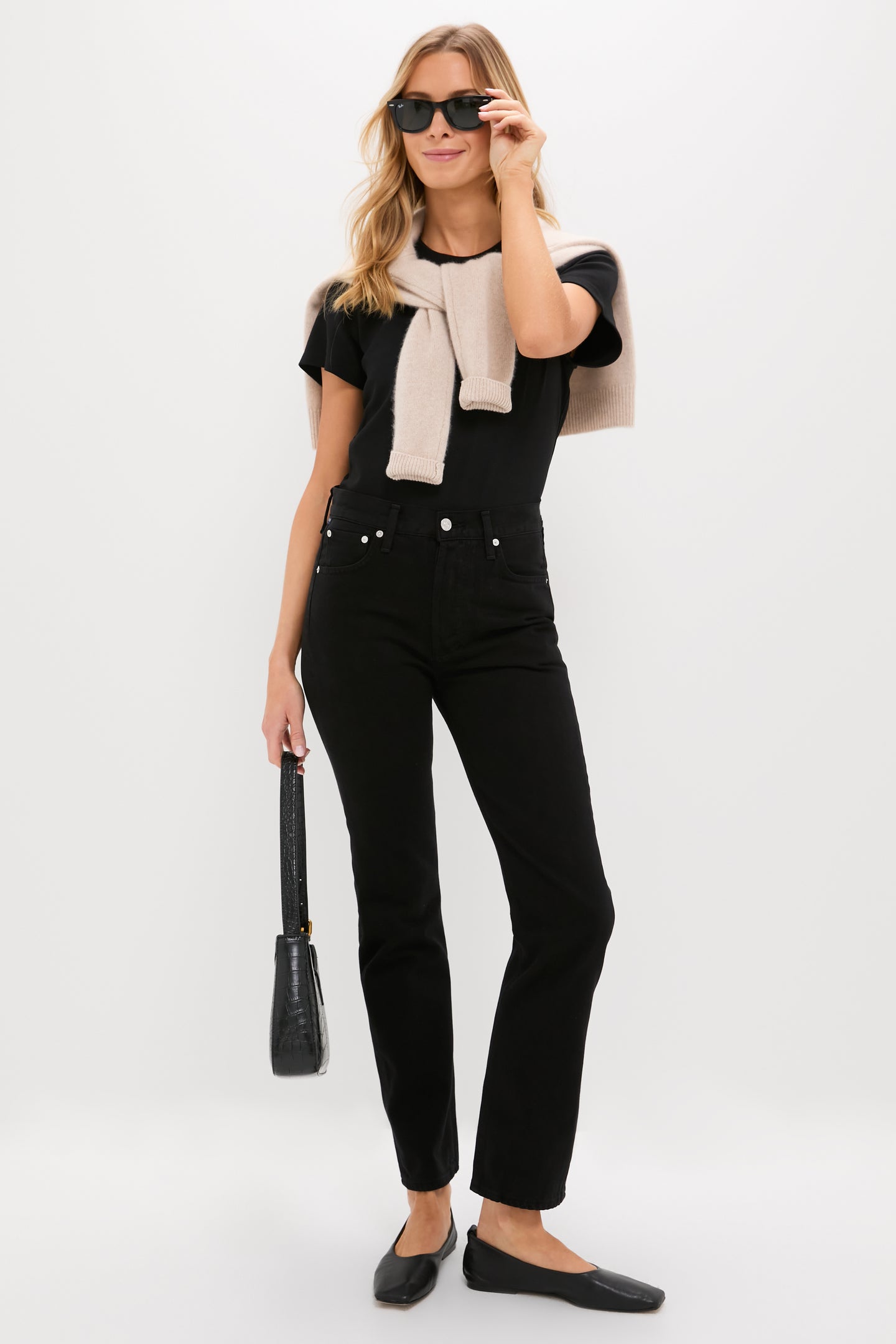 Woman in Solid Black Blaine Jean, high-rise and vintage-inspired, with effortless style; paired with black top and accessories, exuding classic, fun, high-end elegance.