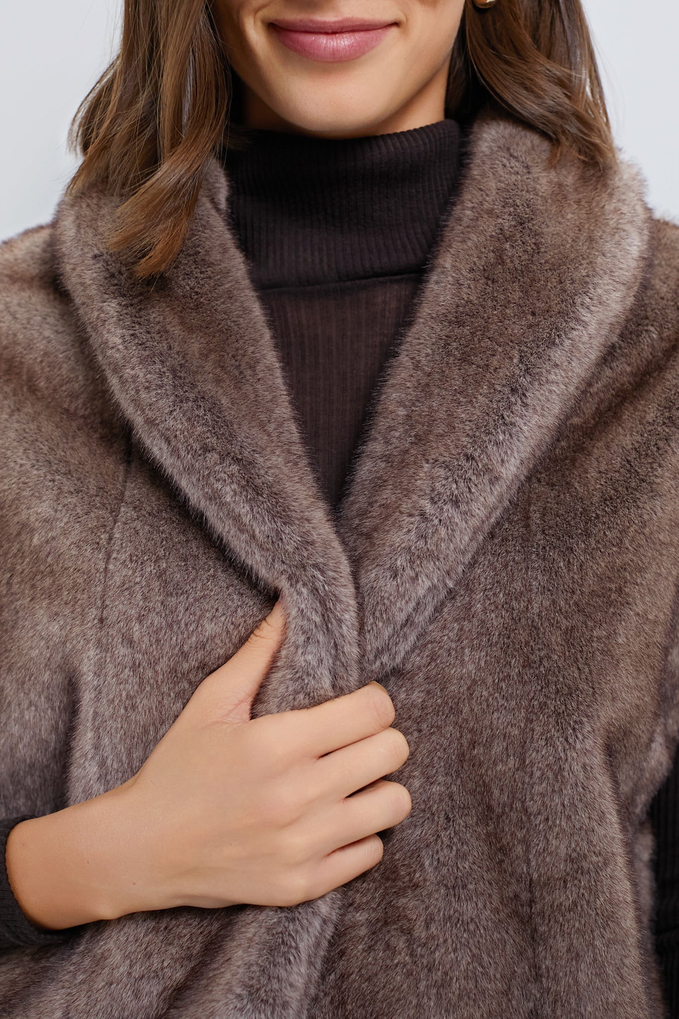 Woman in a classic, oversized Aspen Faux Fur Vest, effortlessly stylish over a dark turtleneck, showcasing a high-end, fun, and relaxed fashion vibe.