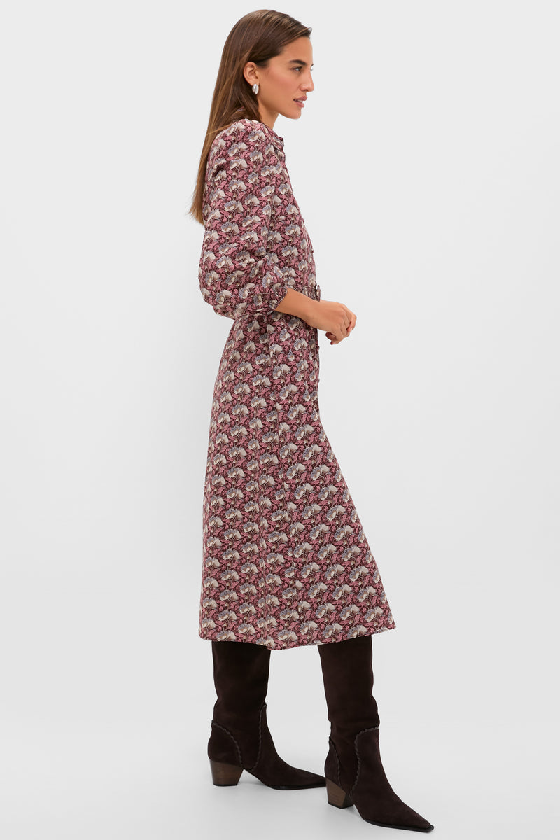 Woman in profile wearing Plum & Dusty Blue Leafy Floral Kai Maxi Dress with puffed sleeves and cinched waist, paired with knee-high suede boots; an effortlessly classic and high-end look.
