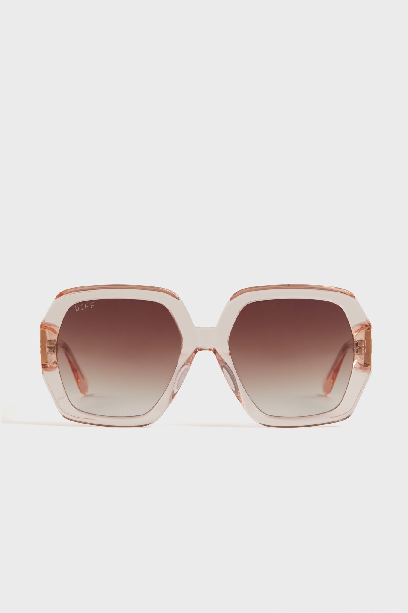 Oversized square sunglasses by DIFF Eyewear featuring light pink translucent frames and brown ombre lenses.