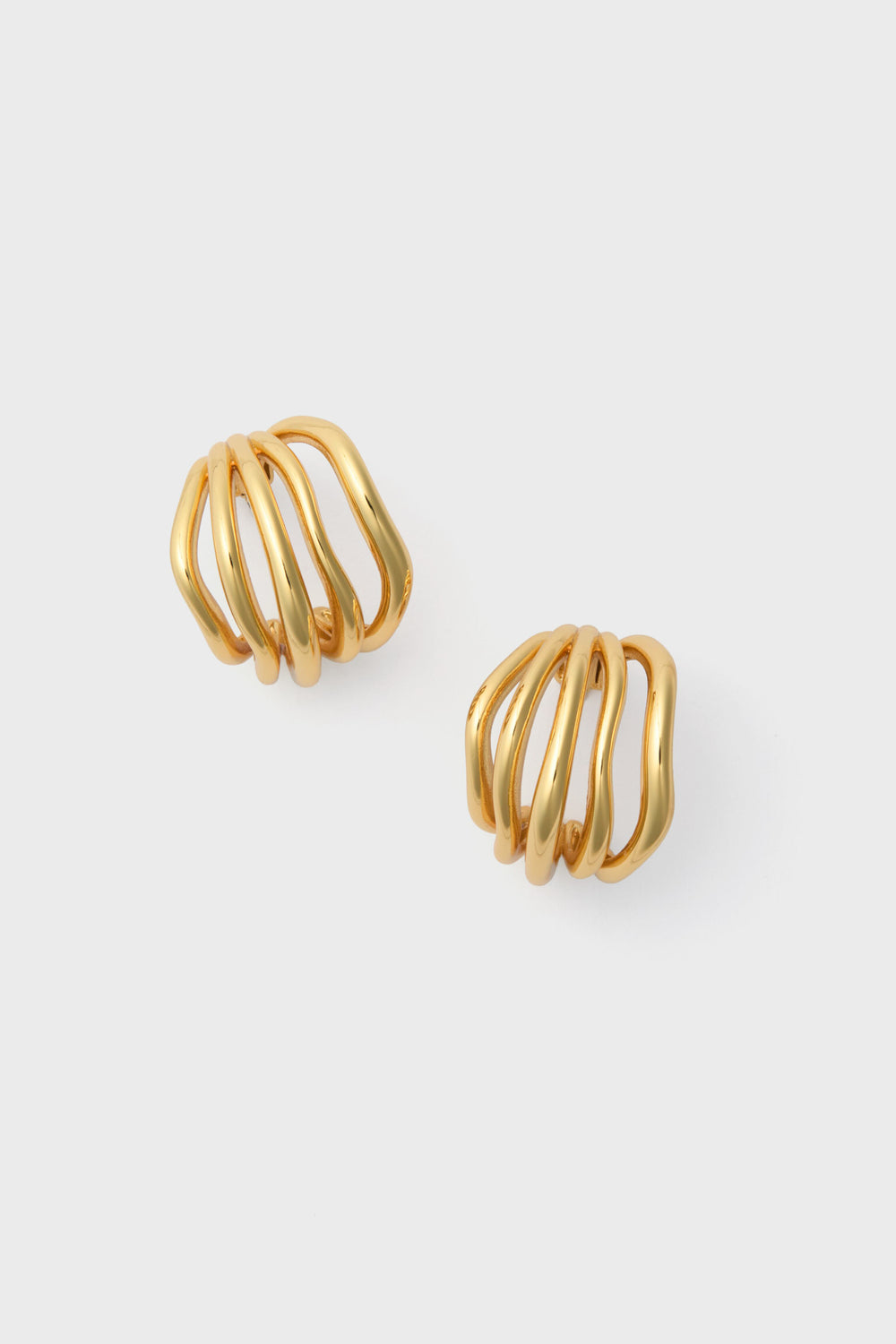 A pair of Gold Sonoma Hoop Earrings featuring a sculptural twist and open cage design by Petit Moments, a female-owned brand.