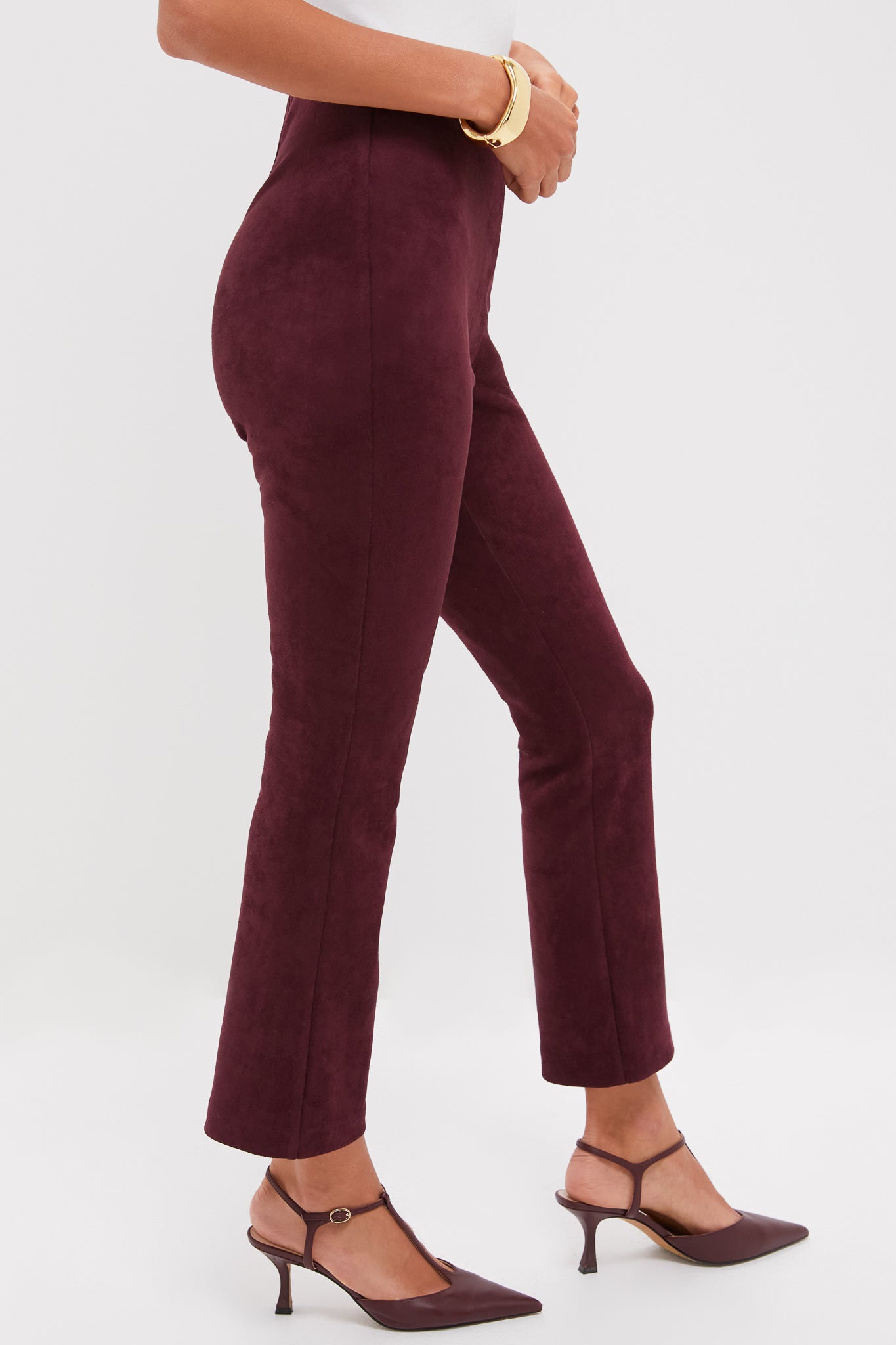 Model wearing classic Winetasting Vegan Suede Ashford Pants with high rise and kick flare hem, paired with matching T-strap kitten heels and a gold bangle. Effortless and high-end style.