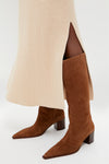 Model showcases the classic Pecan Brown Raffaela Up Mid Boots, featuring a pointed toe and block heel, paired effortlessly with a ribbed knit skirt for a fun, high-end look.