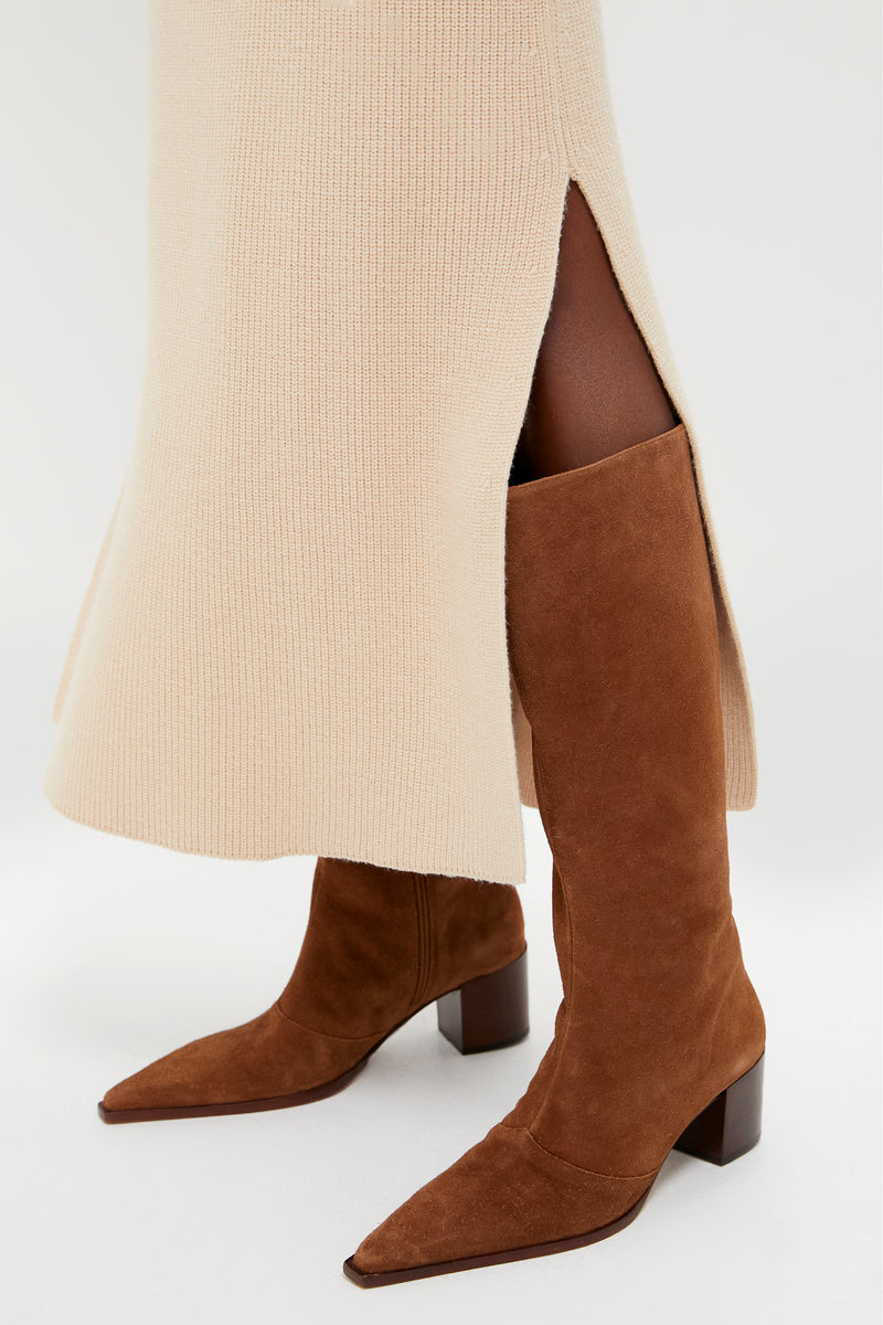 Model showcases the classic Pecan Brown Raffaela Up Mid Boots, featuring a pointed toe and block heel, paired effortlessly with a ribbed knit skirt for a fun, high-end look.