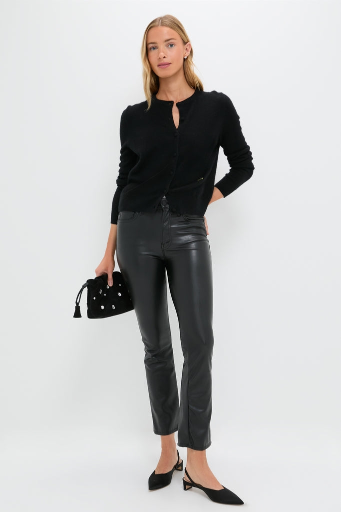 Woman models Exclusive Black Faux Leather The Insider Flood pants, showcasing a classic, effortless style with a slight flare, paired with a chic cardigan and accessories.