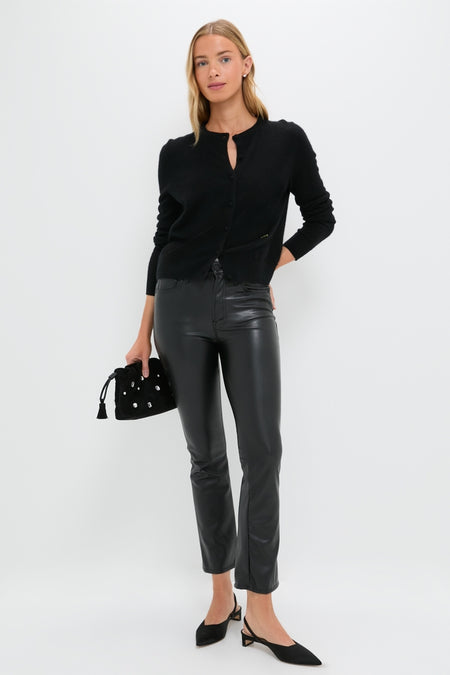 Woman models Exclusive Black Faux Leather The Insider Flood pants, showcasing a classic, effortless style with a slight flare, paired with a chic cardigan and accessories.