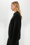 Young woman in a classic, high-end Black Genevieve Cashmere Wool Blend Crewneck Sweater, showcasing its effortless boxy fit and ribbed finishes, perfect for fun, confident styling.