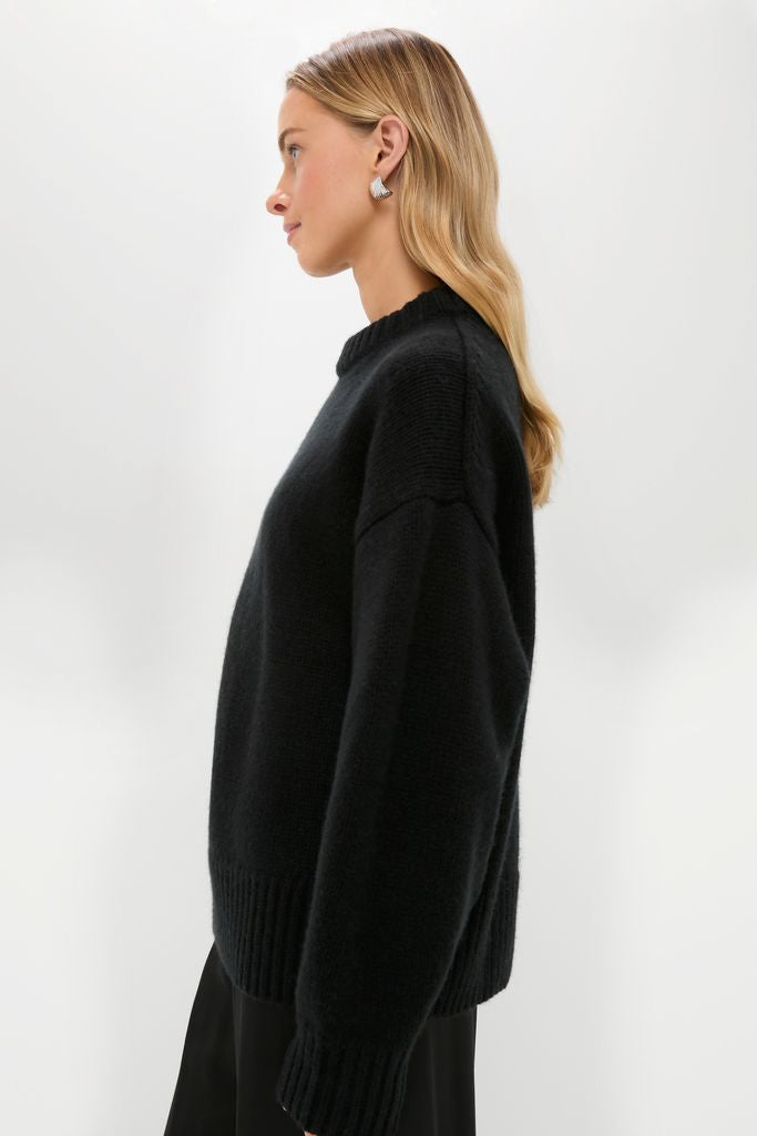 Young woman in a classic, high-end Black Genevieve Cashmere Wool Blend Crewneck Sweater, showcasing its effortless boxy fit and ribbed finishes, perfect for fun, confident styling.