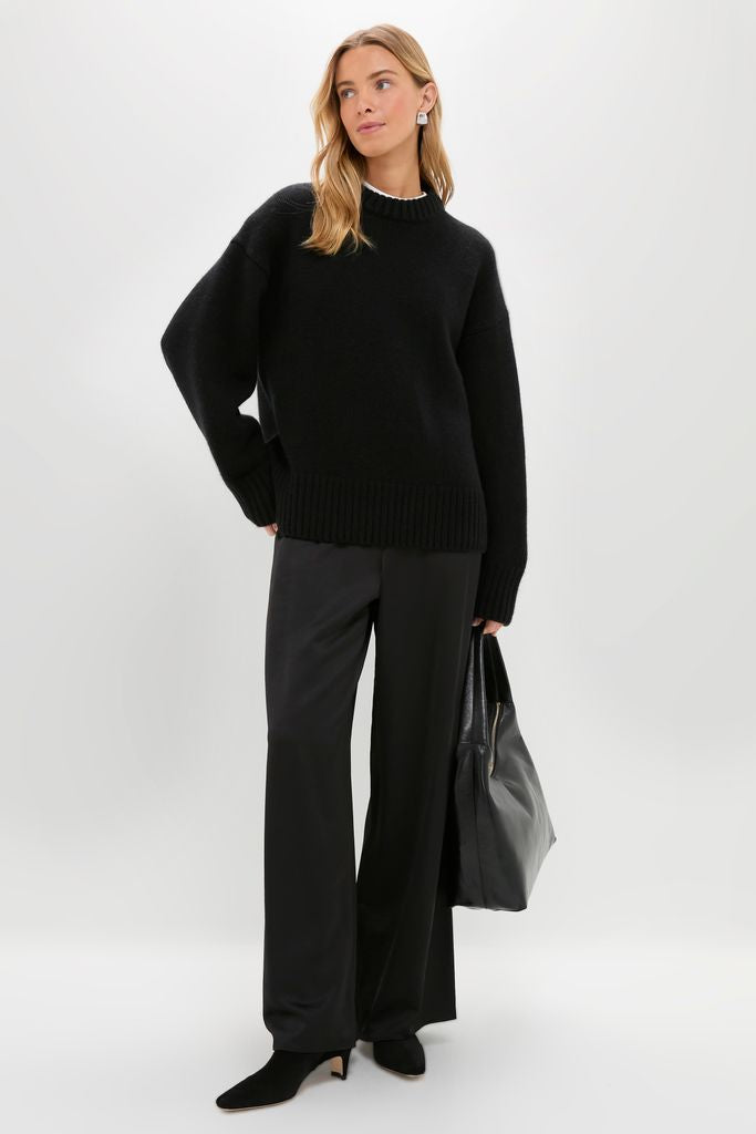 Model in Black Genevieve Cashmere Wool Blend Crewneck Sweater, embodying classic, effortless style with chunky knit and ribbed details, paired with chic wide-leg trousers and accessories.