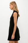 Young woman in profile wearing the Black Cable Knit Mini Saxon Dress—sleeveless, fit-and-flare, effortlessly classic, perfect for fun, high-end styling.