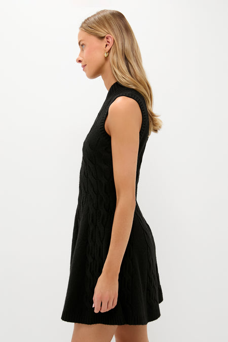 Young woman in profile wearing the Black Cable Knit Mini Saxon Dress—sleeveless, fit-and-flare, effortlessly classic, perfect for fun, high-end styling.