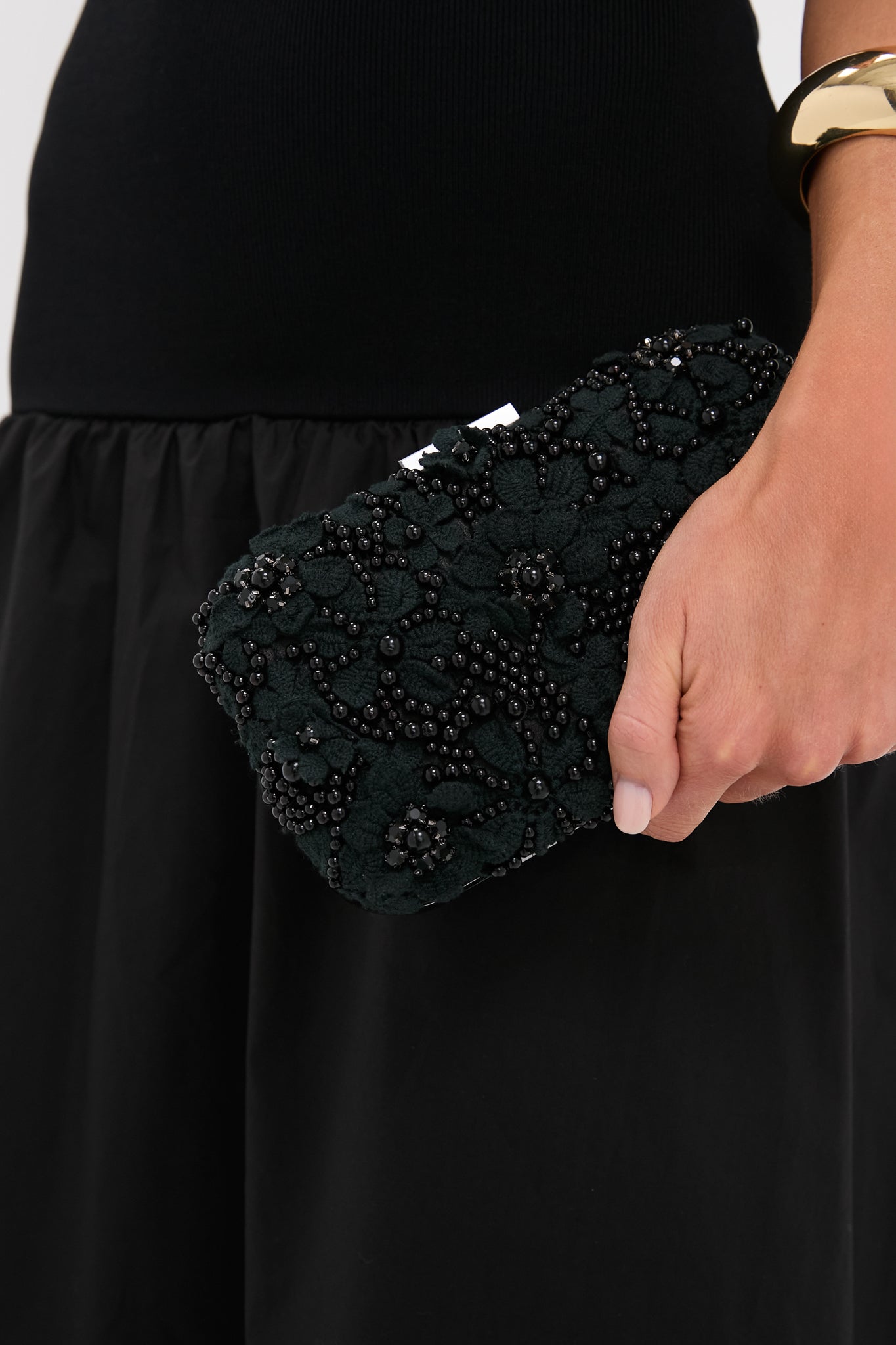 Hand holding the Black Beth Encrusted Clutch, featuring classic floral embroidery and bead embellishments, exuding an effortless, high-end style perfect for fun, formal occasions.