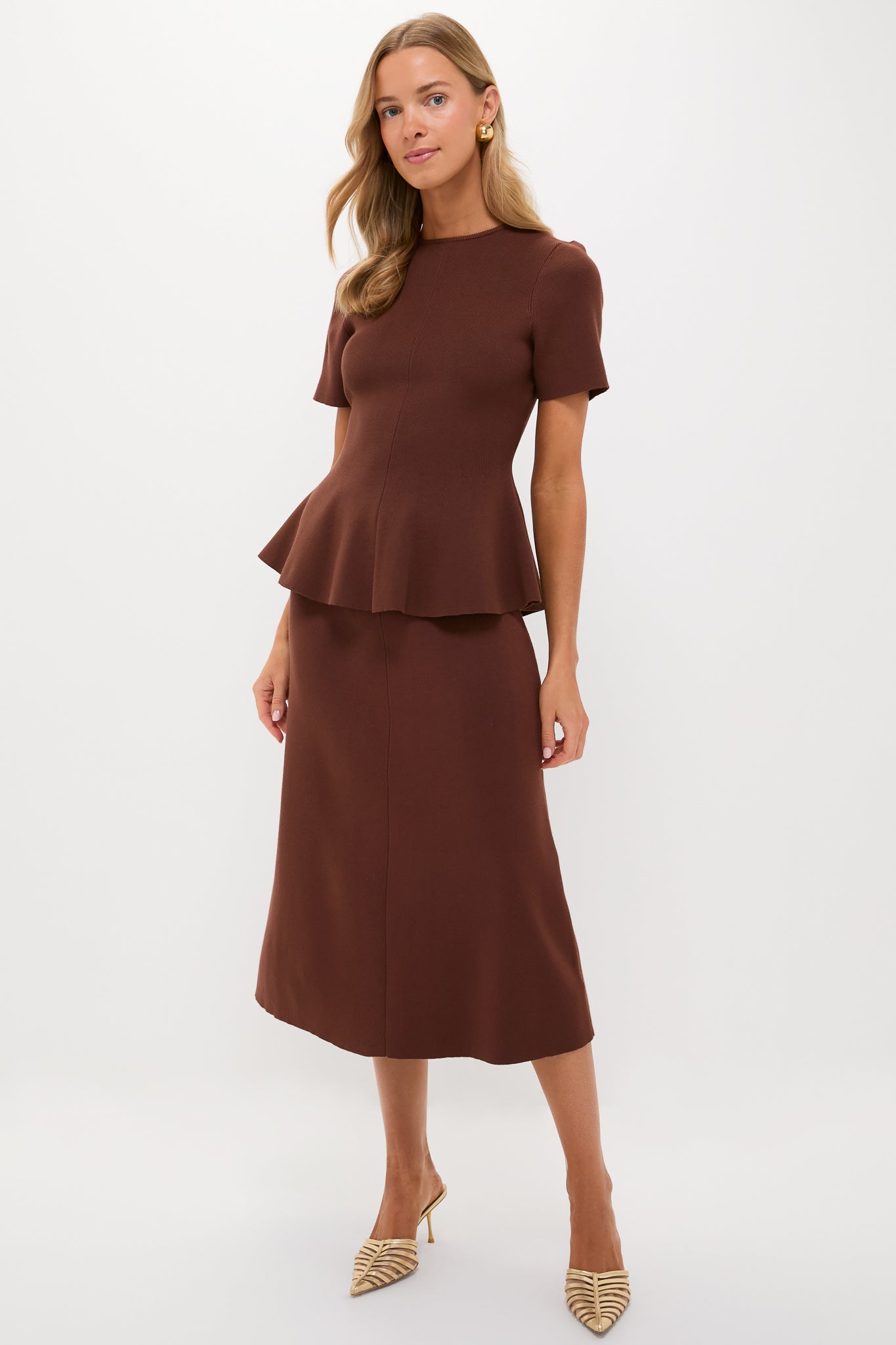 Model in a classic, effortless Chocolate Brown Knit Phoebe Peplum Top with short sleeves, peplum hem, paired with an A-line midi skirt for a high-end, fun look.
