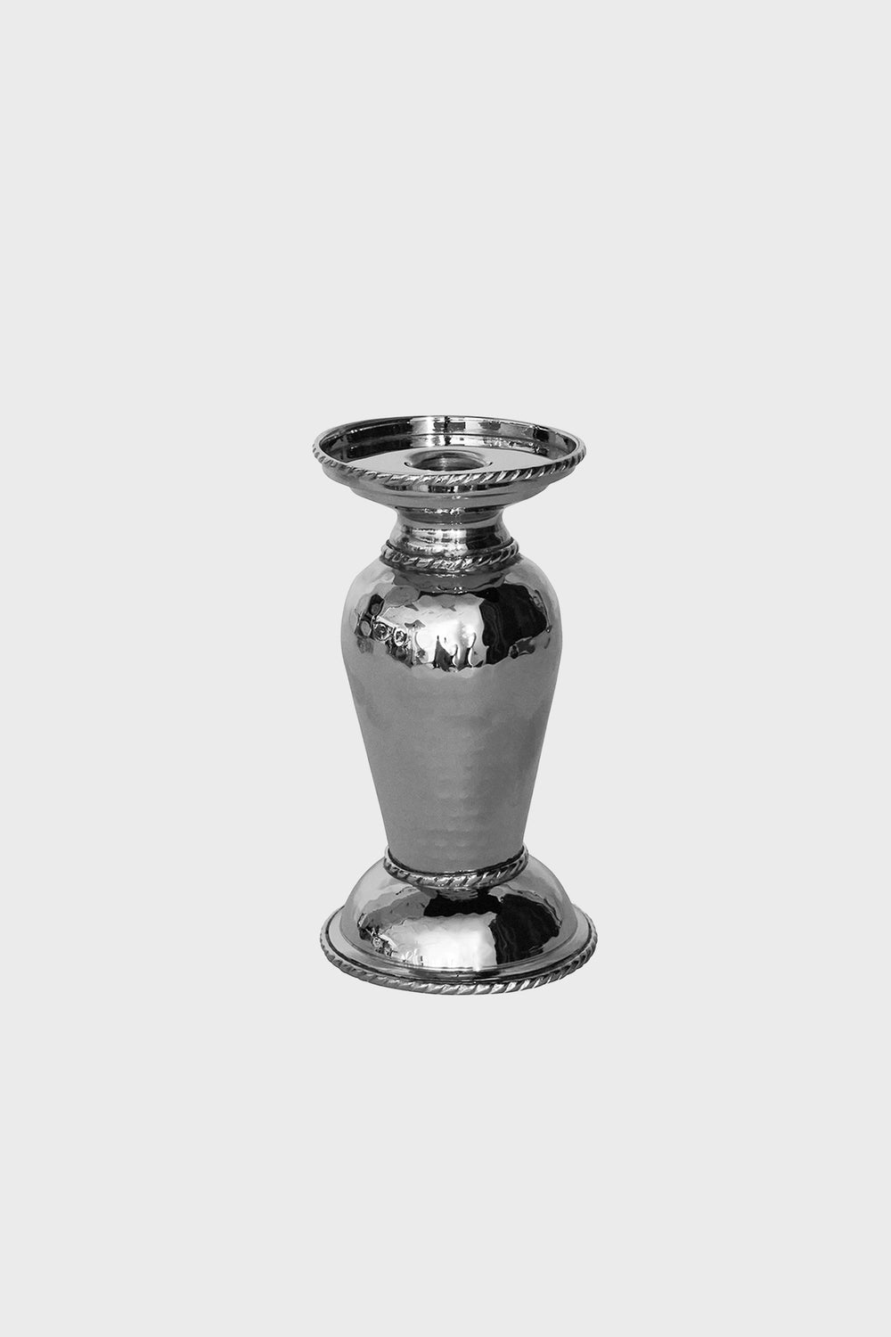 The Juliska hammered stainless steel candle holder features a shiny finish, wide rim and base, and decorative edges—ideal for displaying taper or pillar candles.