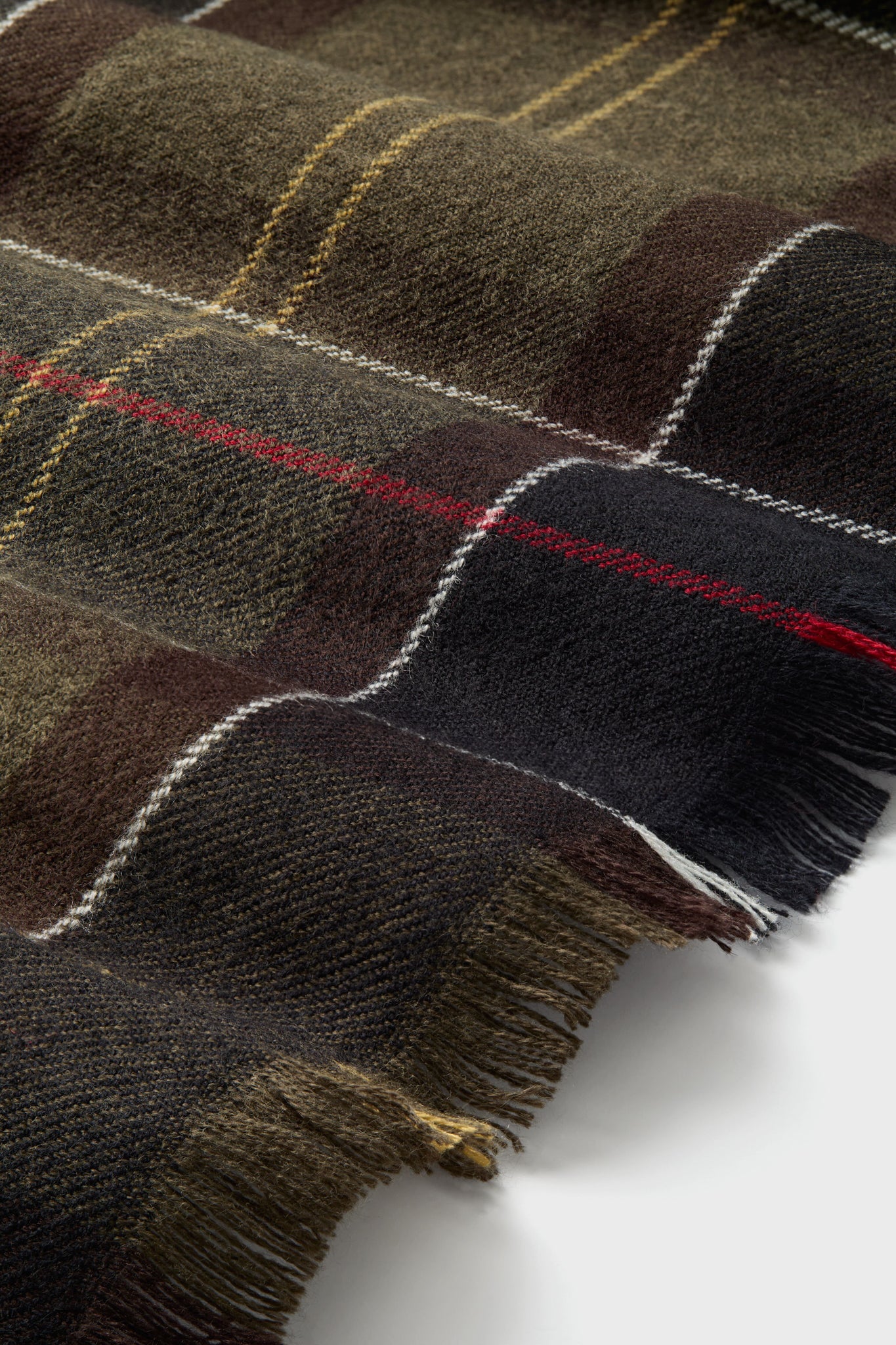 Staffin Tartan Serape: A classic, high-end fringed wool textile with a plaid pattern, offering effortless style and fun versatility for cool days. Perfect for sophisticated comfort.