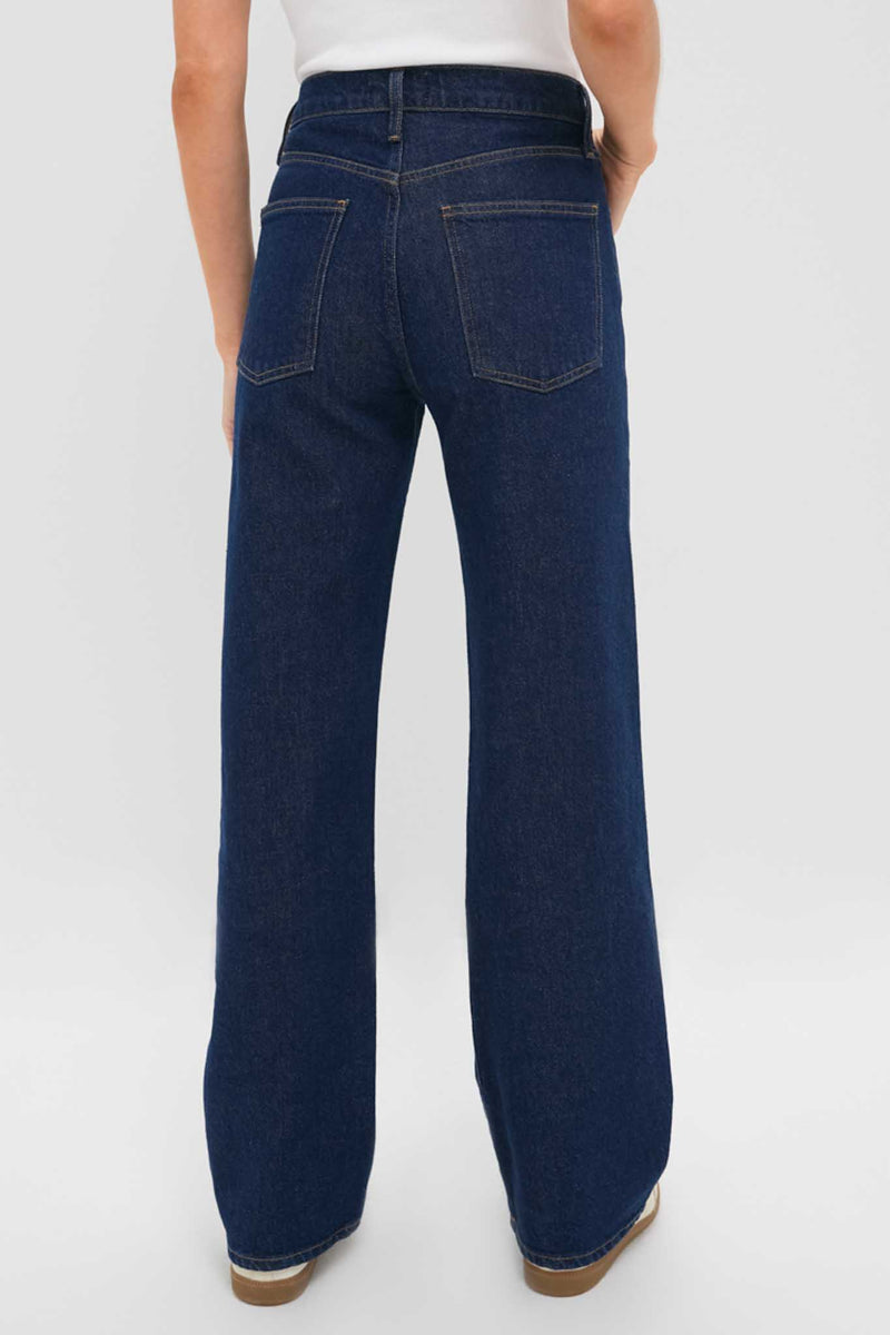 Back view of classic Reissue Mid Rise Relaxed Straight Harper Jean in dark-indigo, showcasing high-waisted, wide-leg design with contrast stitching and clean hem for an effortless, high-end look.