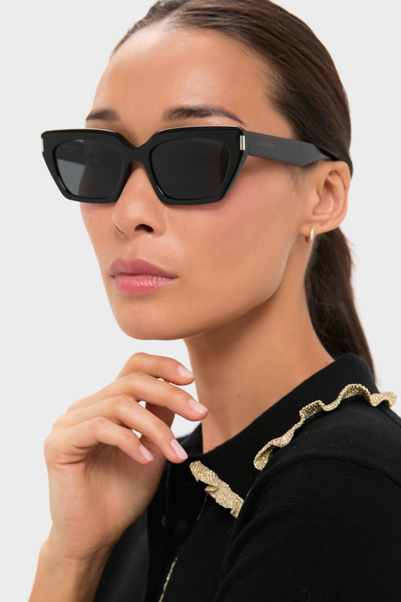 Woman wearing Shiny Solid Black Corner Angle M Sunglasses with a classic cat-eye frame, exuding an effortless, high-end style. Her look is fun and confidently chic.
