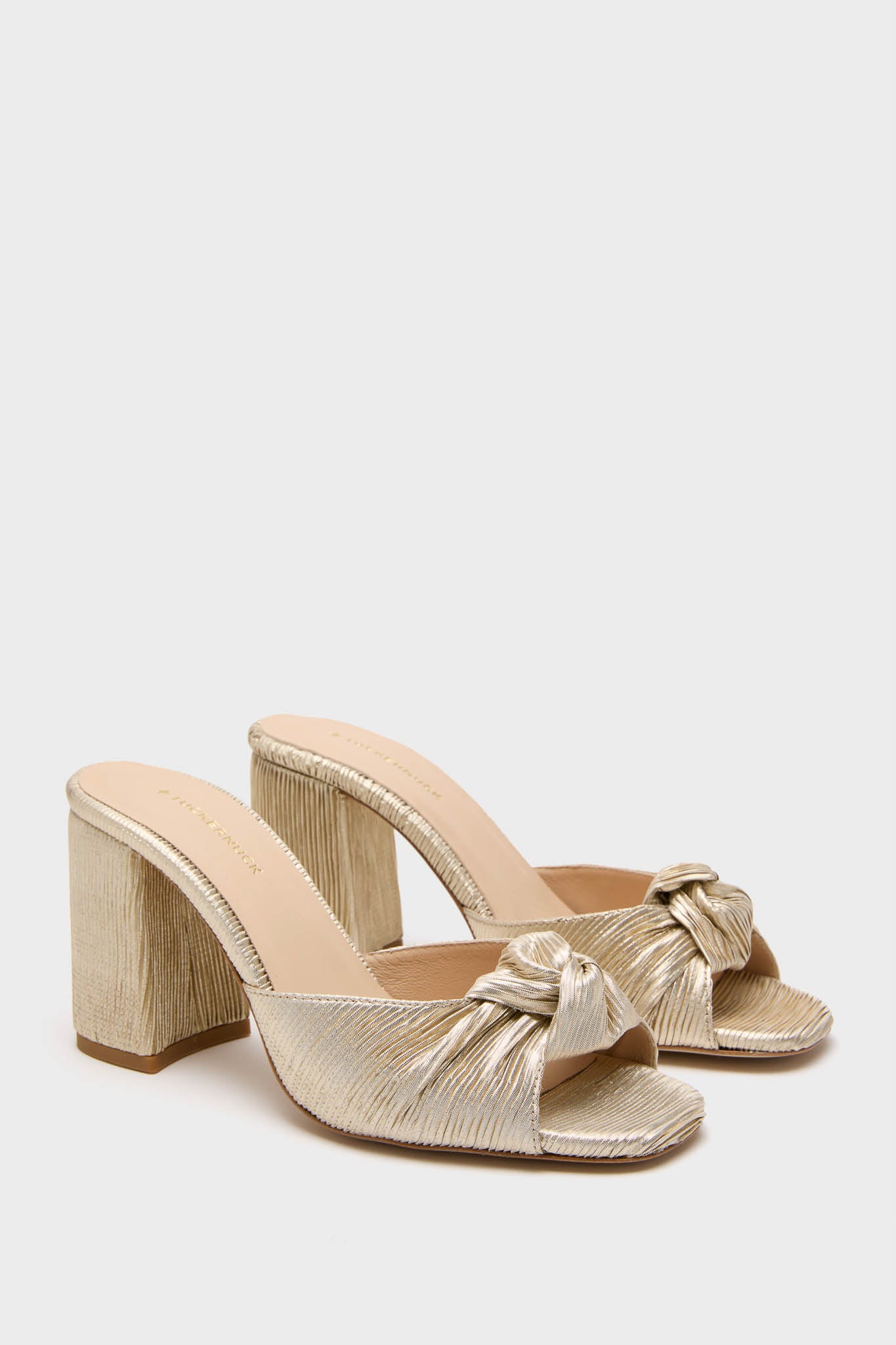 Gold Pleated Blake Heels: classic women’s slide-on mules with a chunky block heel, featuring a metallic textured finish and twisted-knot detail for an effortless, high-end look.