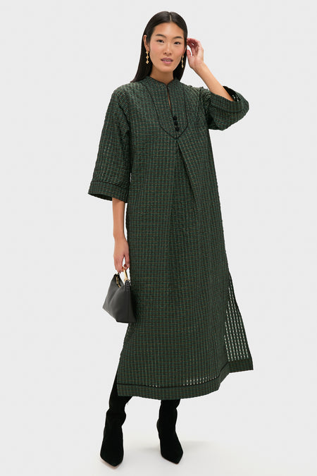 Woman models a classic, high-end dark green dress with a subtle pattern, accessorized with Berry Clover Linear Earrings - Gold, creating an effortless, fun look.