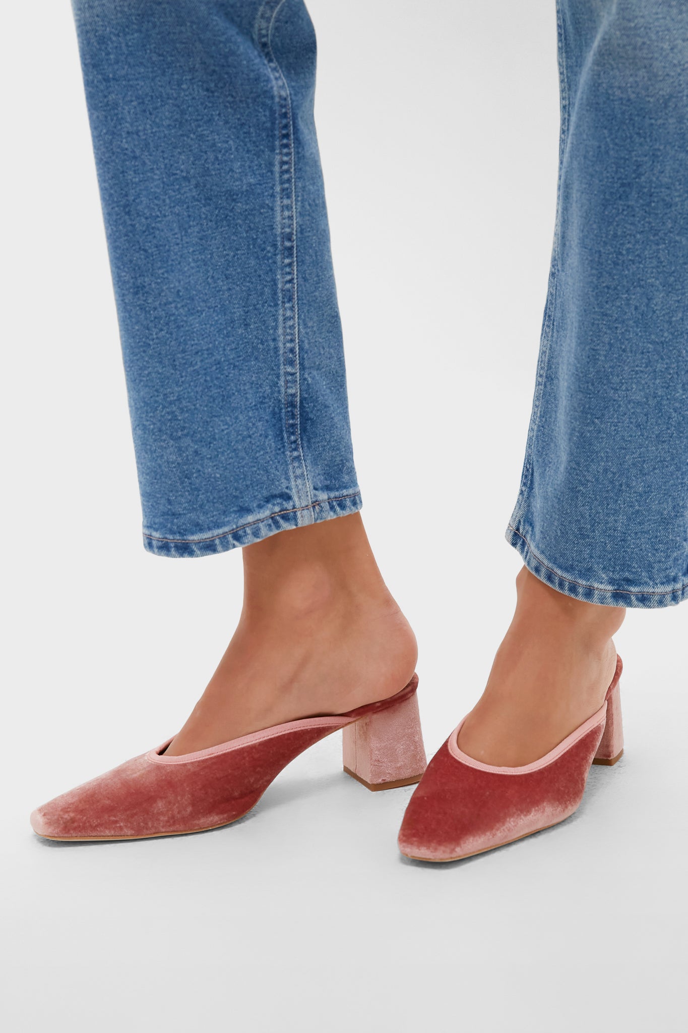 Blush Velvet Tilda Mules, classic and effortless; women's muted pink velvet mules with square-toe, block heels, paired stylishly with blue jeans.