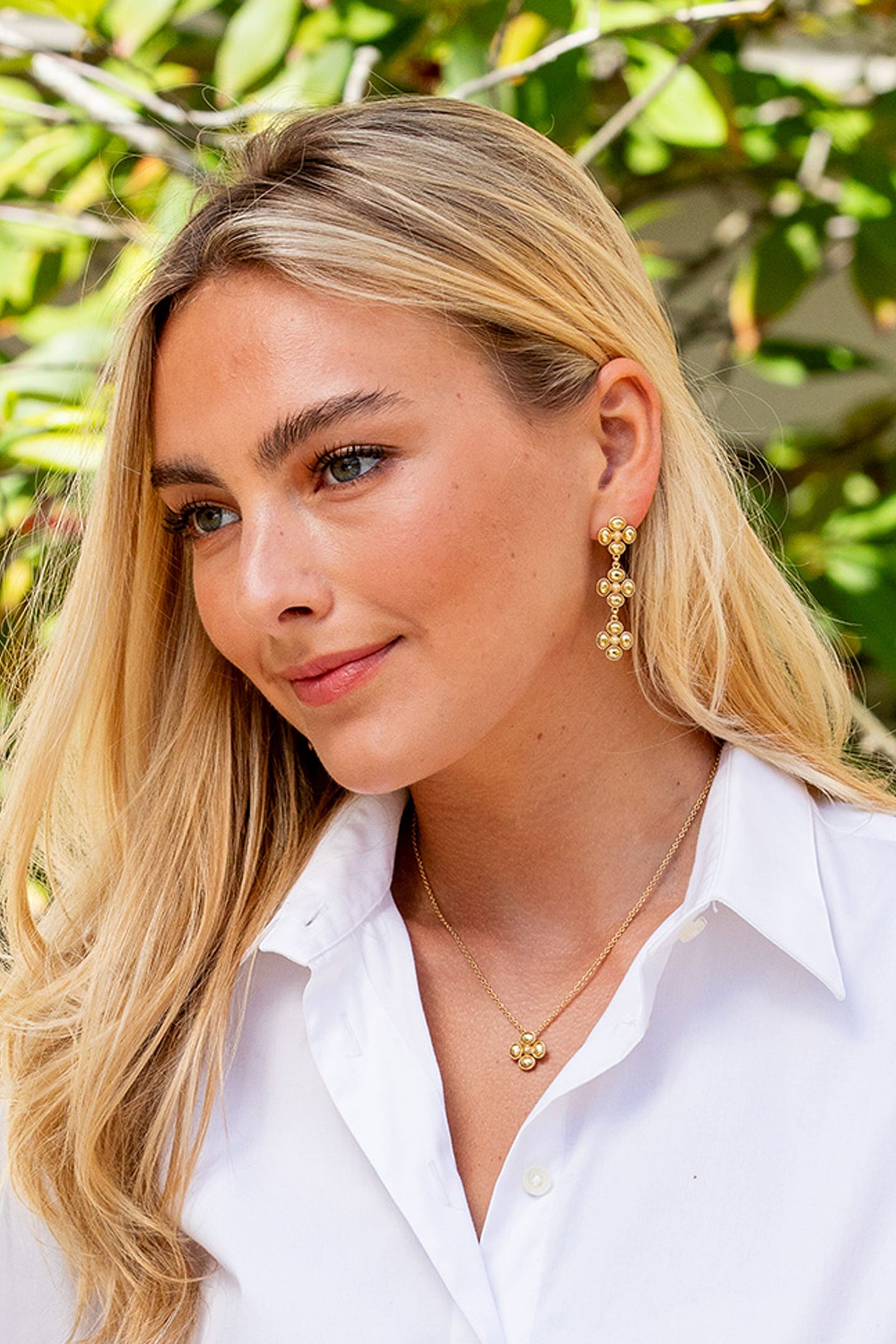 Young woman wears Berry Clover Linear Earrings - Gold, showcasing classic, effortless style with dangling clusters, perfect for a high-end, fun outdoor look.