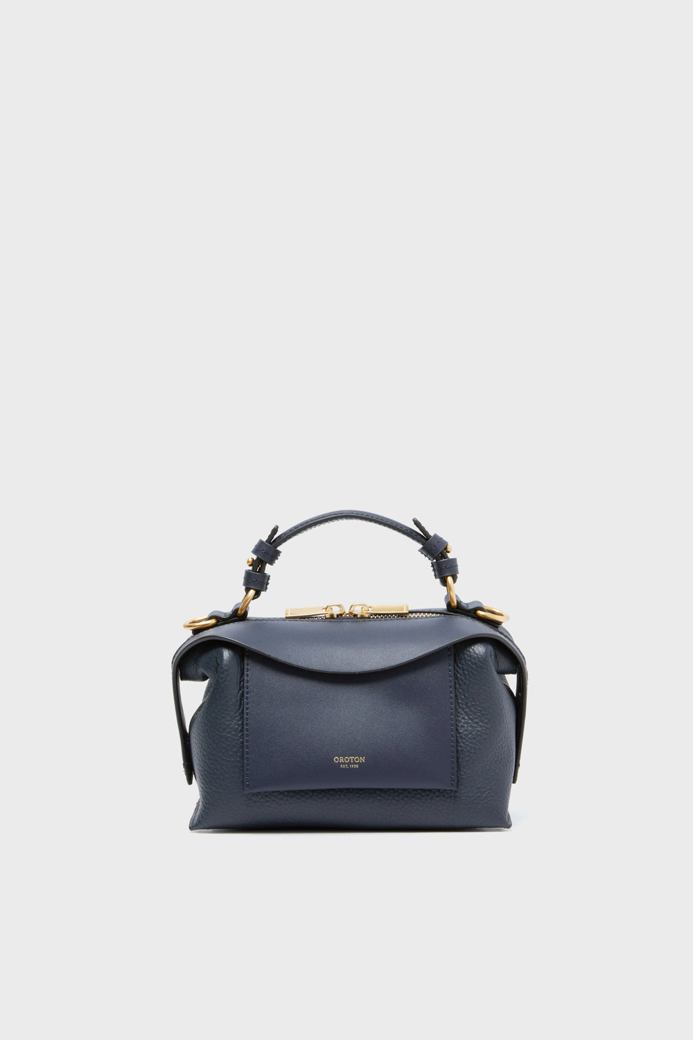 The Oroton North Sea Mica Mini Bowler in dark blue features a structured design, top handle, gold hardware, front pocket, and can also be worn as a crossbody bag.