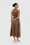 Regio Brown Silk Gioia Midi Dress with classic smocked bodice and keyhole closure, styled effortlessly with cream block-heeled sandals, exuding a high-end, fun sophistication.
