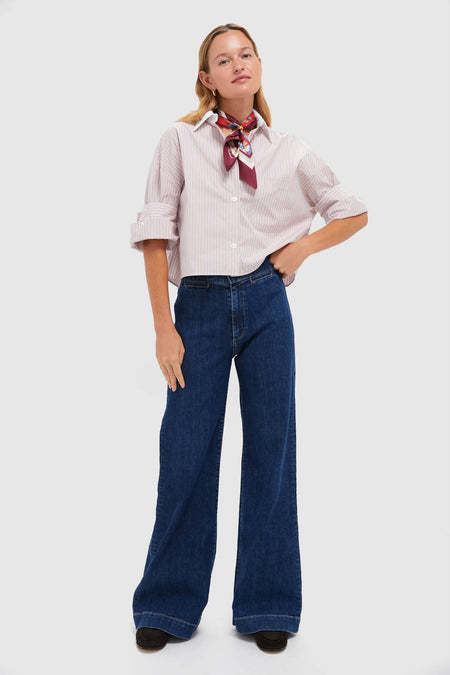 Person wearing Dark Stone Brighton Jean, high-rise and wide-leg, paired with a striped button-down and silk scarf. A classic, effortless, and fun high-end look.