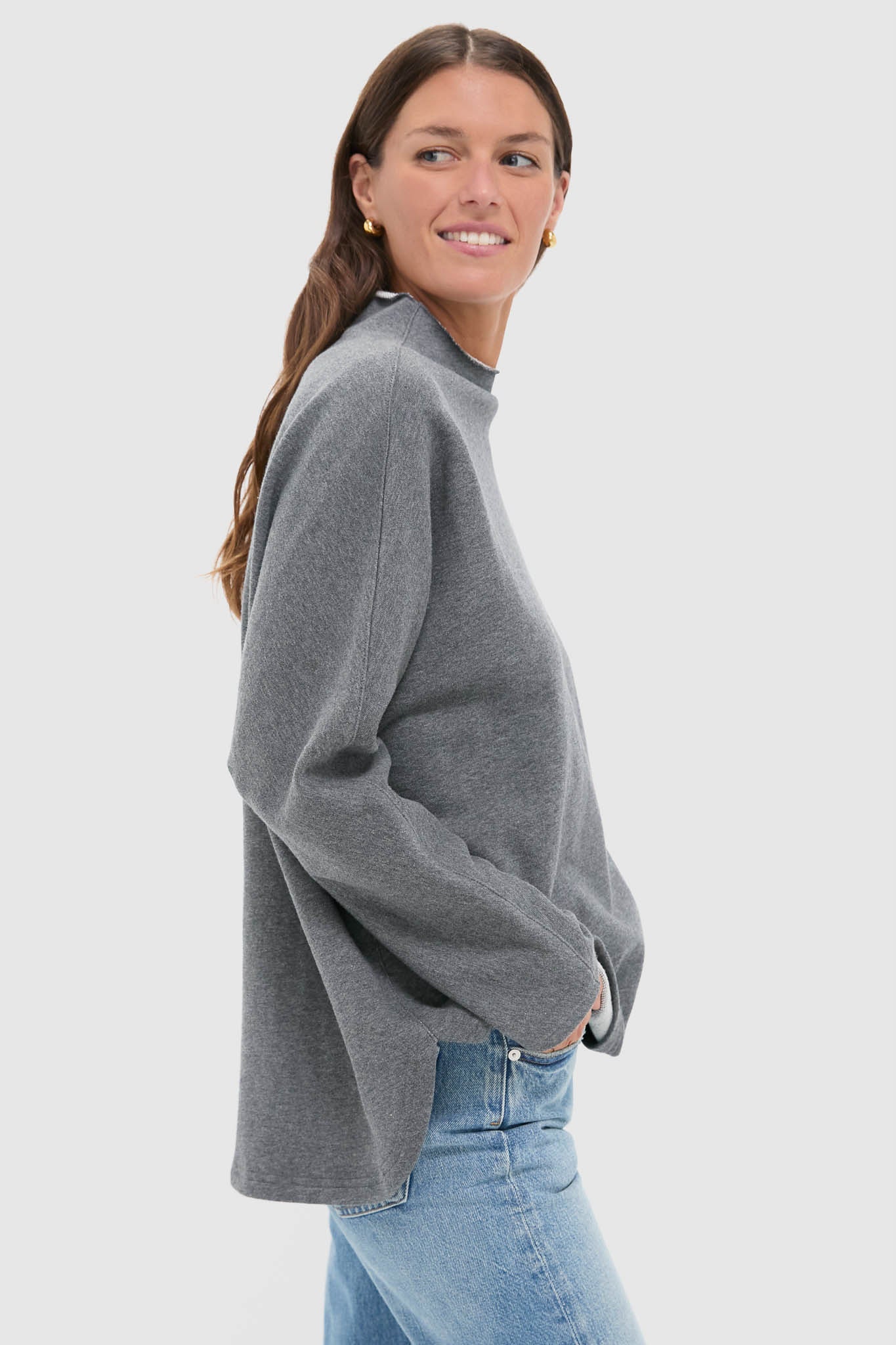 Young woman wearing the classic Slate Gray Bowie Popover, showcasing its effortless swing shape and batwing sleeves, paired with jeans for a fun, high-end look.