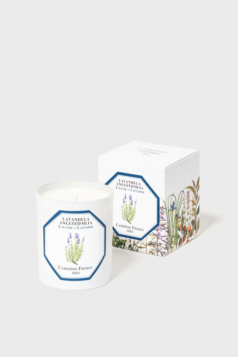 A Carrière Frères white lavender candle made from vegetable wax in a glass jar labeled Lavandula Angustifolia, shown next to its decorative box adorned with botanical illustrations.
