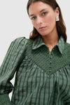 Young woman models the classic Green Windowpane Seersucker Vail Blouse with effortless smocking details, puff sleeves, and cinched cuffs, epitomizing Tuckernuck's fun, high-end style.