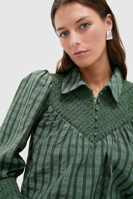 Young woman models the classic Green Windowpane Seersucker Vail Blouse with effortless smocking details, puff sleeves, and cinched cuffs, epitomizing Tuckernuck's fun, high-end style.