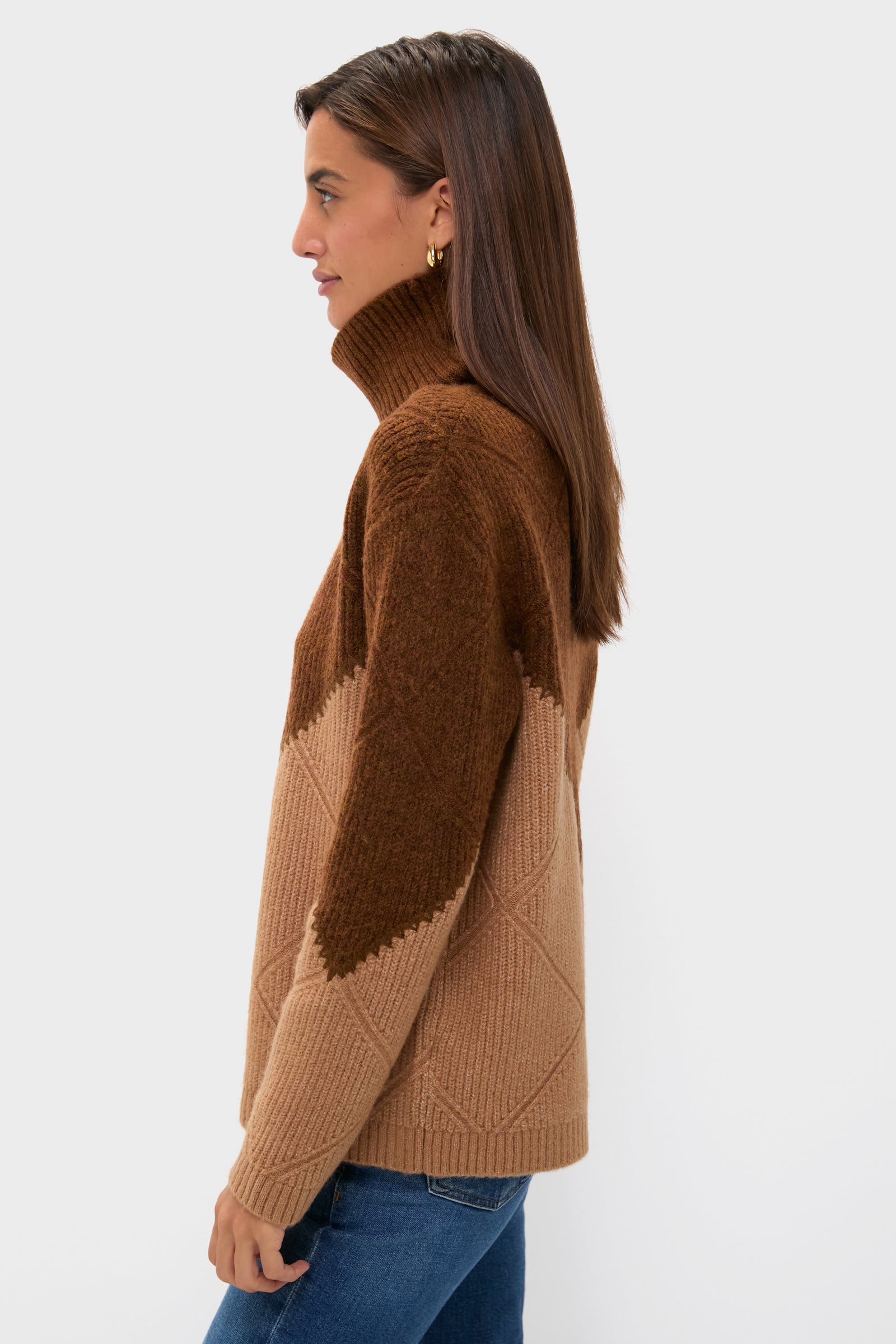 Woman in profile wearing Tan & Brown Diamond Demi Turtleneck, showcasing classic, effortless style with a high-end knit design and whipstitch details, paired with blue jeans.