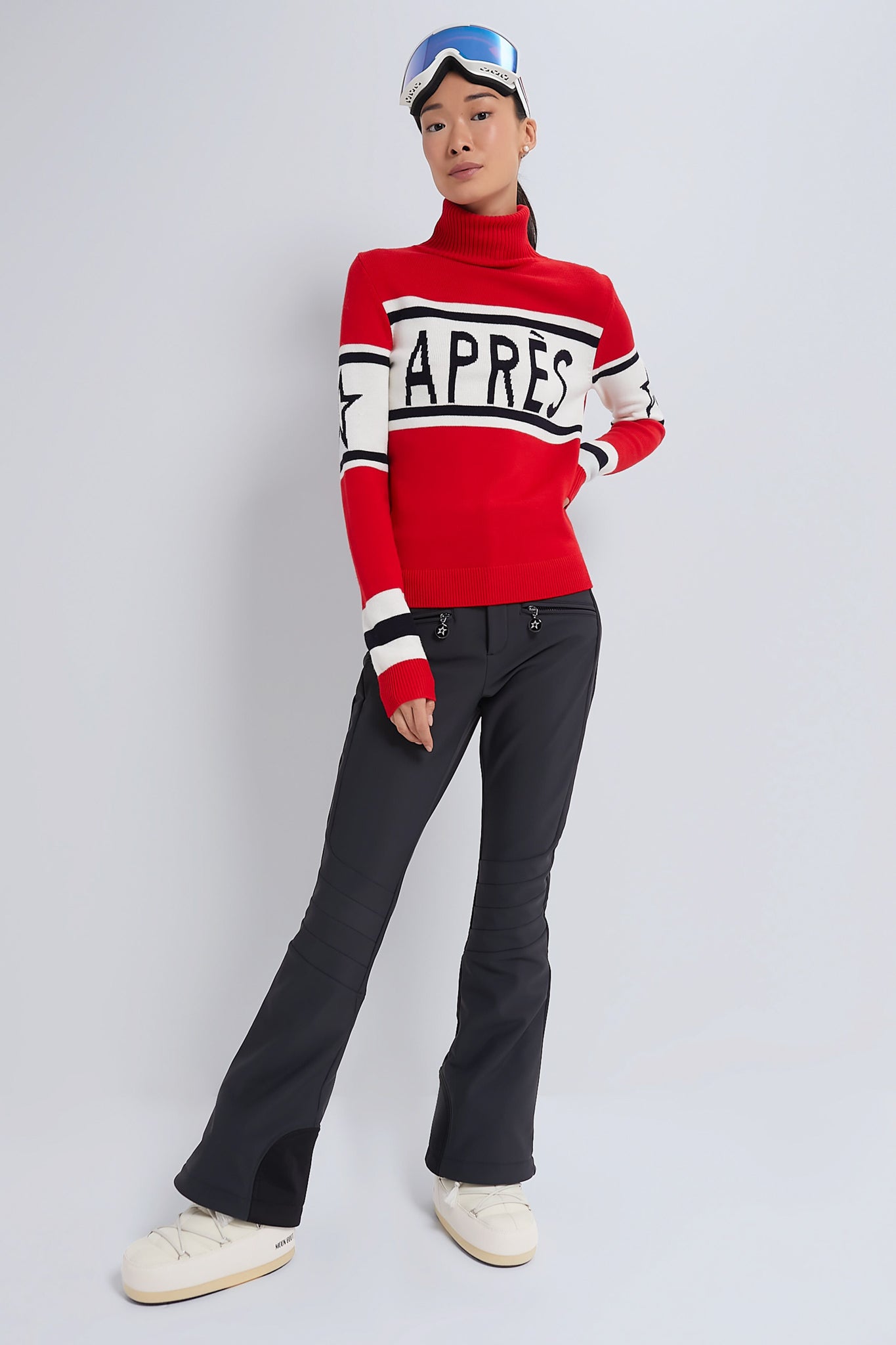 Person sporting Black Aurora High Waist Ski Pant with a classic, effortless fit, styled with après-ski flair, showcasing high-end design and fun, modern performance features.