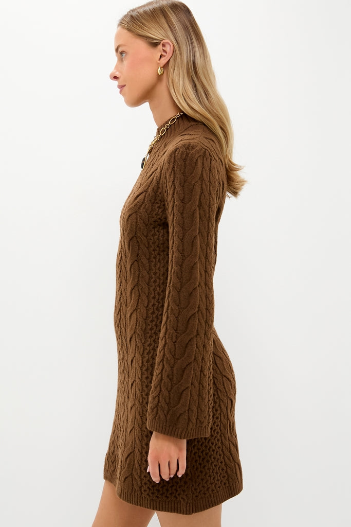 Model in Coffee Cable Knit Lucia Mini Dress, showcasing classic, effortless style with a mock neck and flared sleeves, accessorized with gold jewelry for a high-end look.